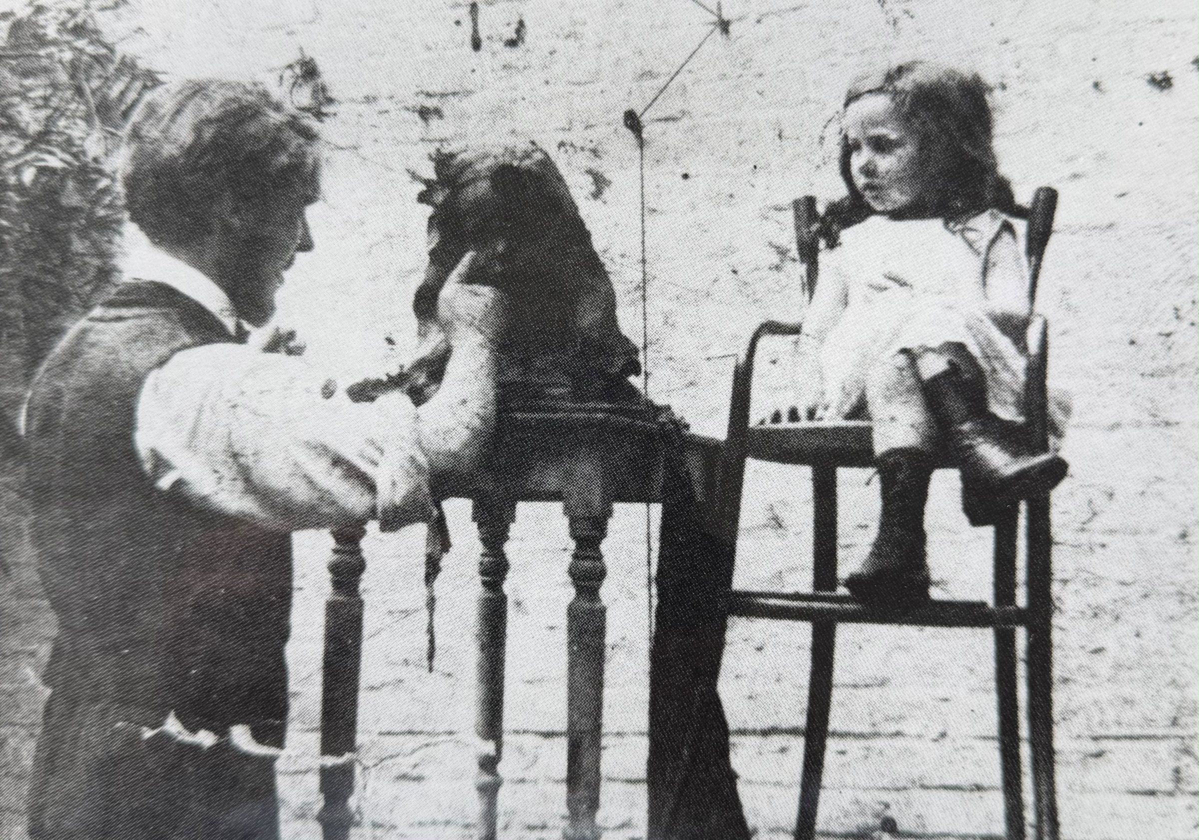 Rik Wouters modelling a bust on a stand beside a young girl seated in a high chair
