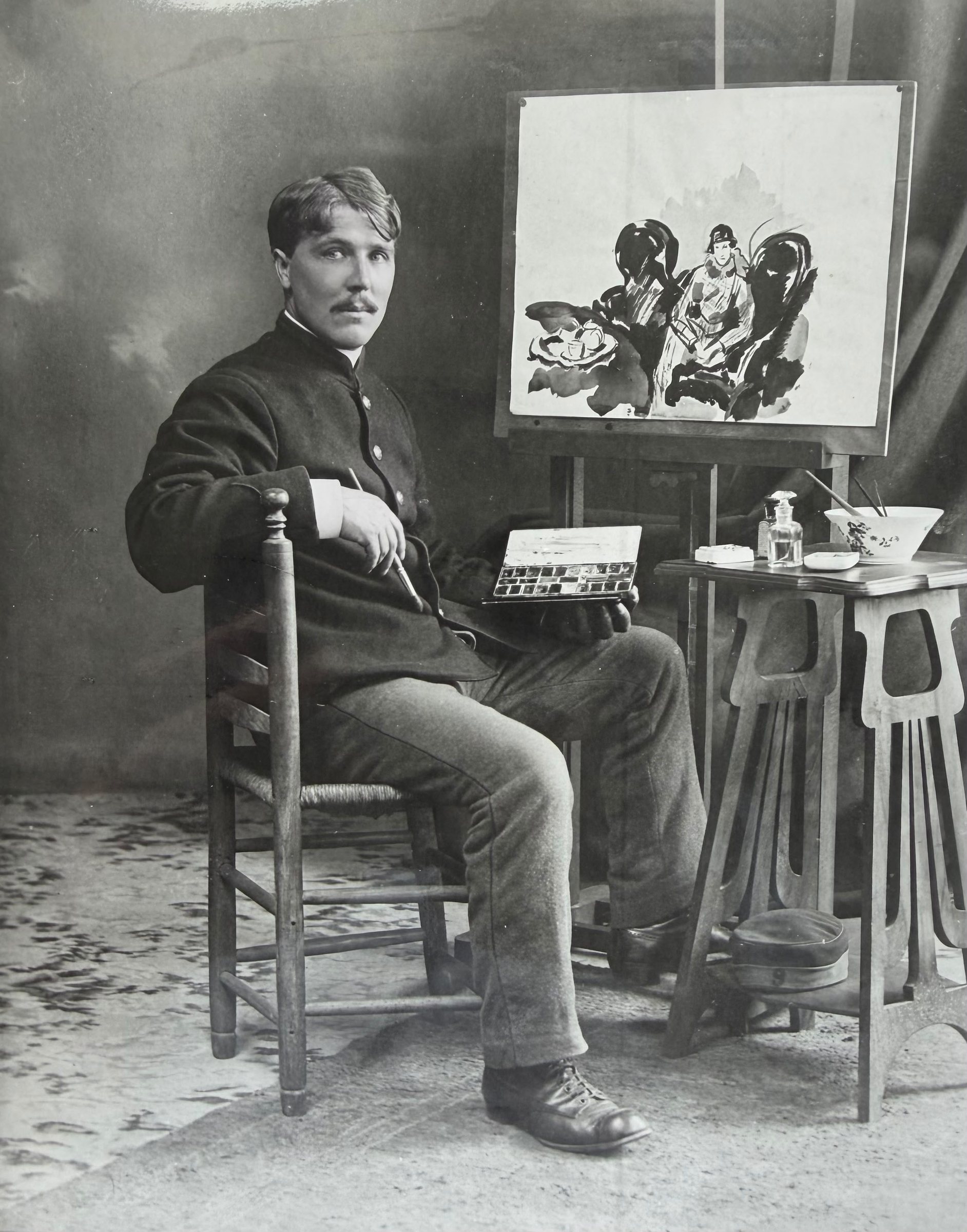 Rik Wouters seated beside an easel holding a watercolour box