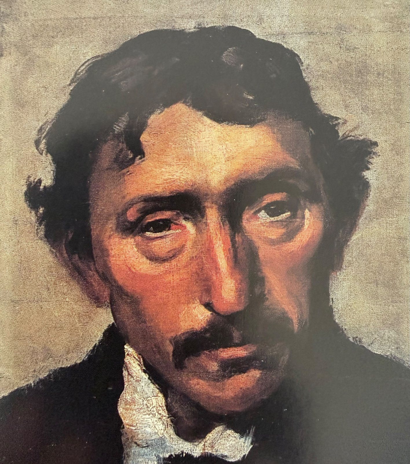 Close portrait of a man with dark hair and a moustache