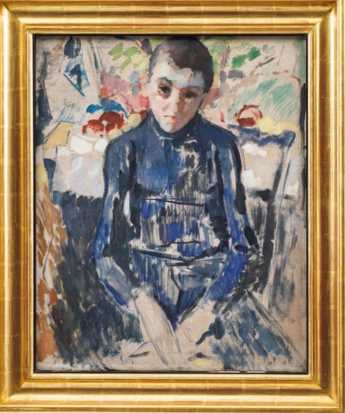A child in a blue garment seated before a table with flowers